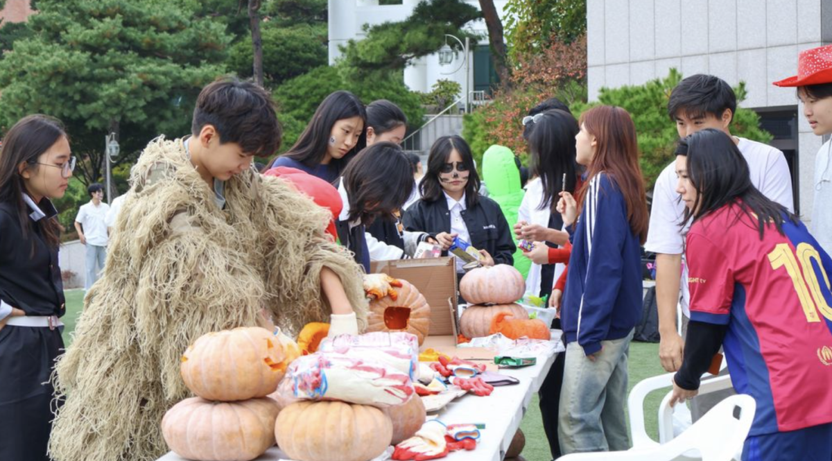 Students participating in the pumpkin carving event during the Fall Festival